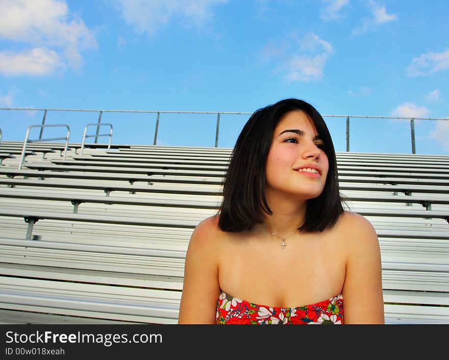 Woman watching a sporting game from the bleachers. Woman watching a sporting game from the bleachers.