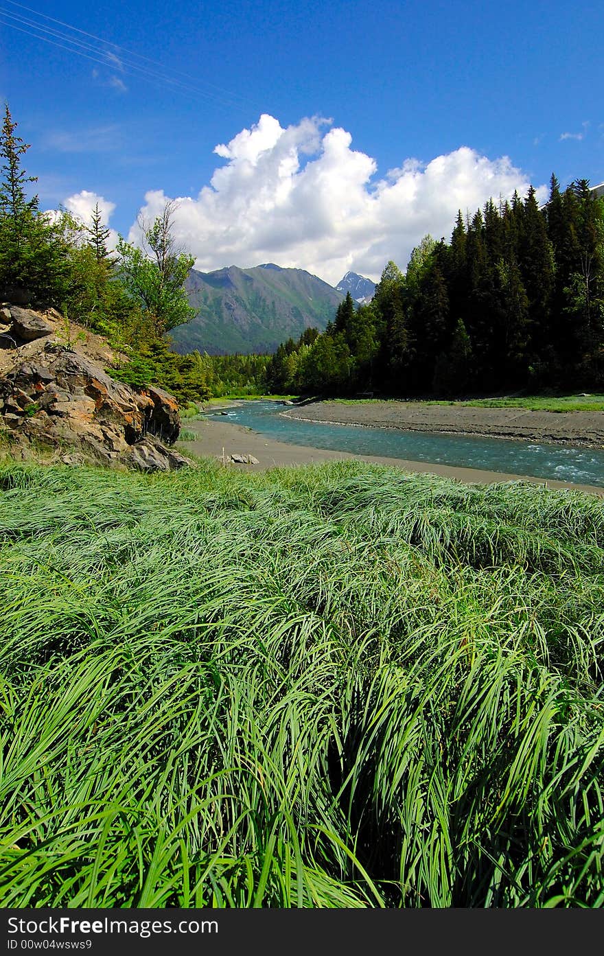 Near Anchorage, Alaska, on Hwy 1, river, mountains, meadows and greenery. Near Anchorage, Alaska, on Hwy 1, river, mountains, meadows and greenery.