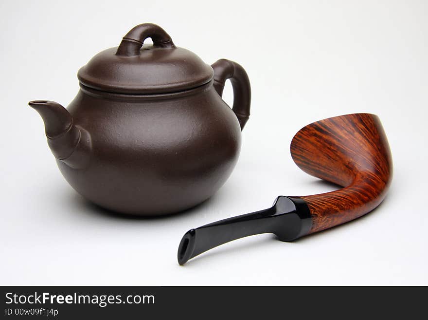 Tobacco pipe and Teapot on white background.