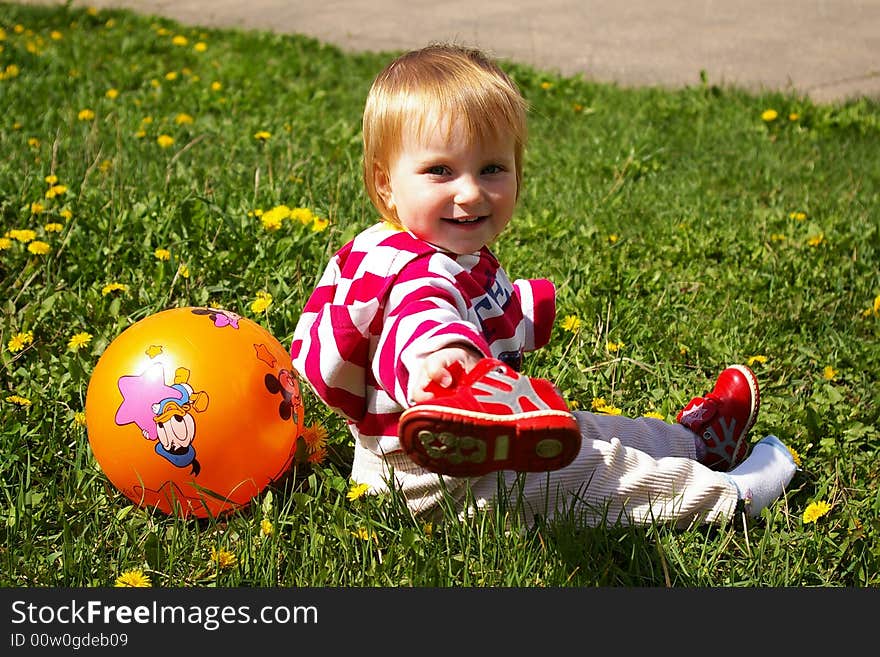 Girl with a ball on a grass