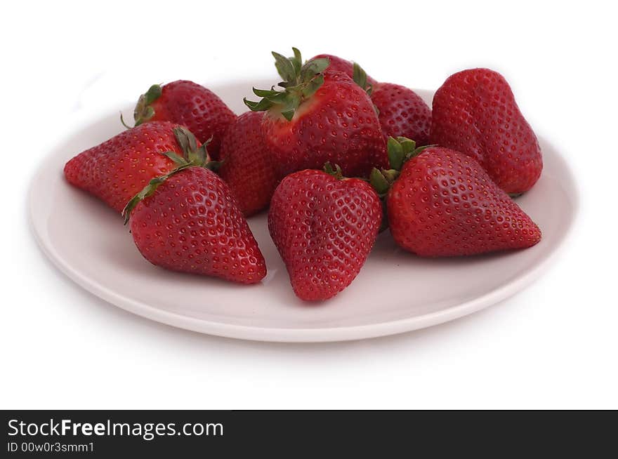 Red, juicy strawberries on white plate on white background