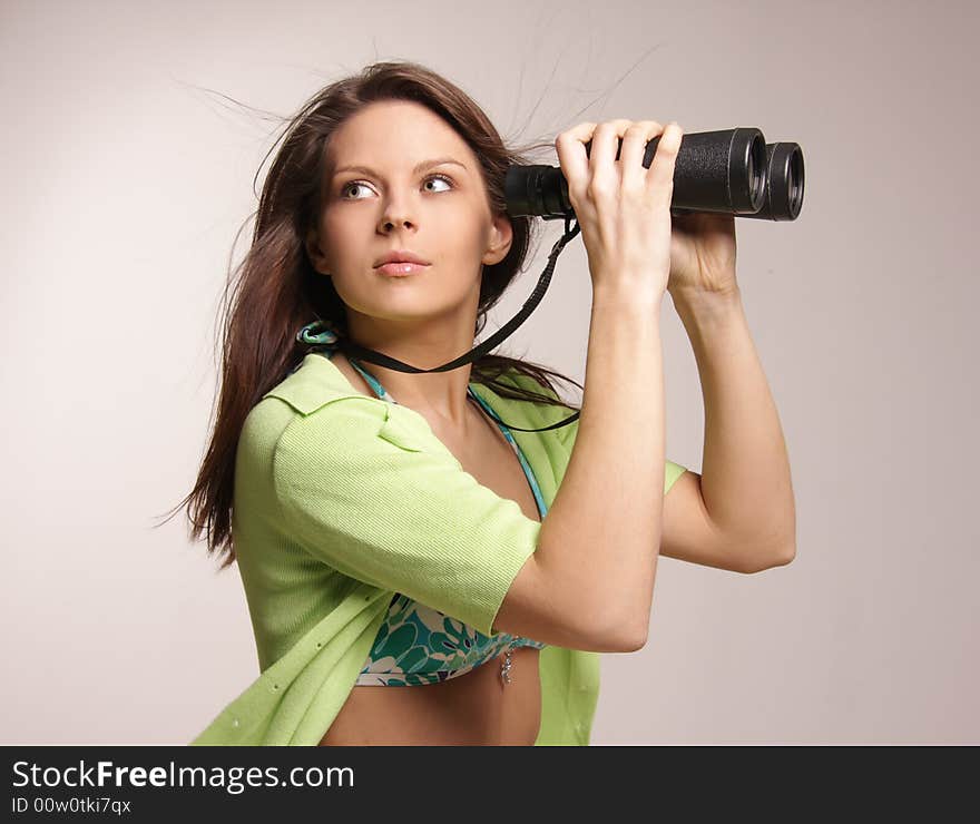 Beautiful, attractive woman looking through binoculars.