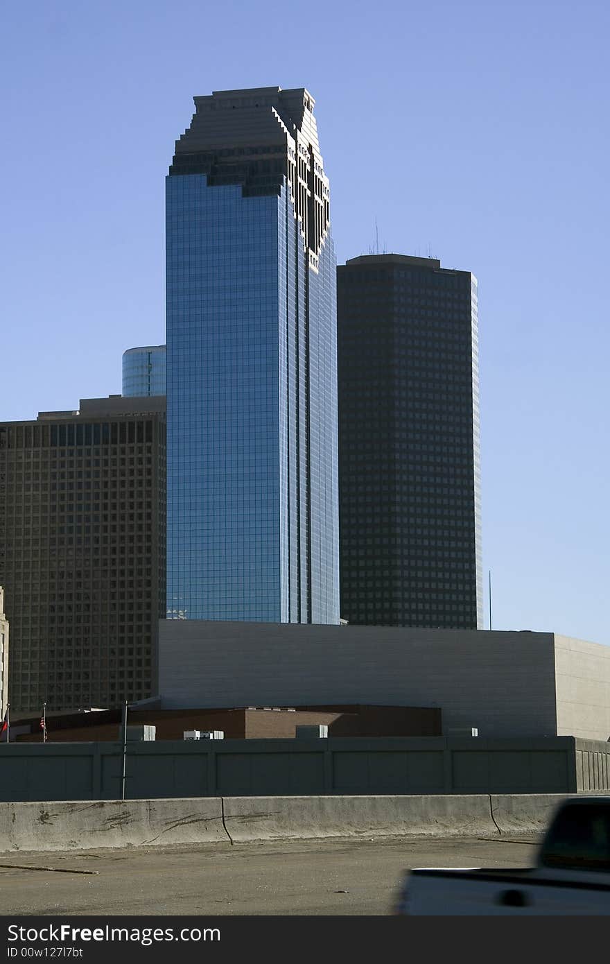 A vehicle driving by downtown office buildings