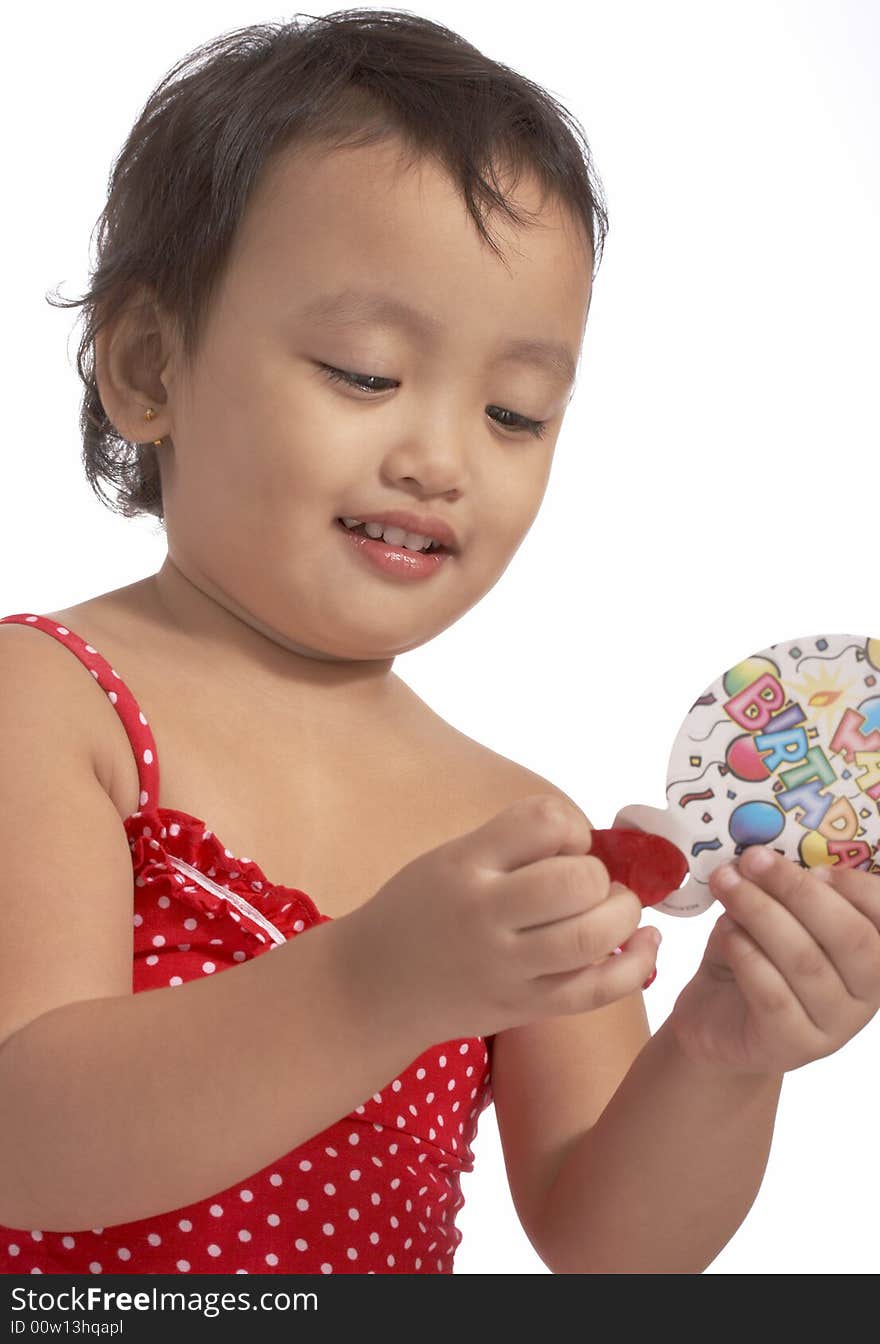 Little girl in red dress holding party popper