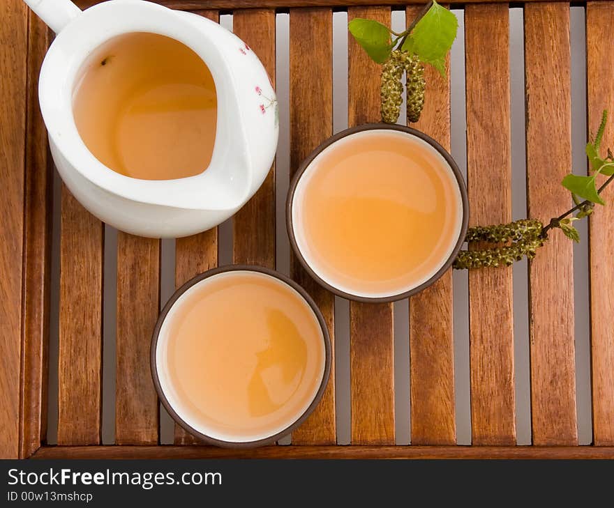 Green tea in cups serving on wooden tray.