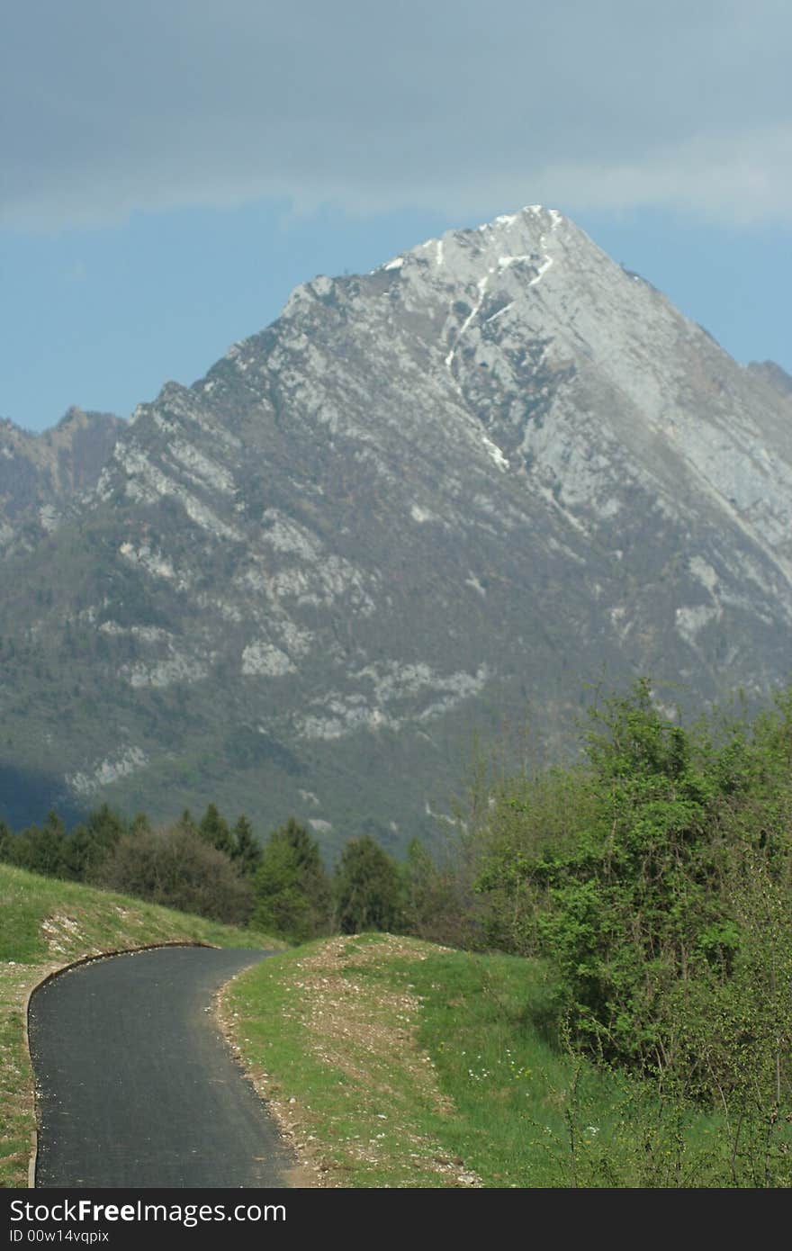 Road that carry between lawns up to the mountain. Road that carry between lawns up to the mountain