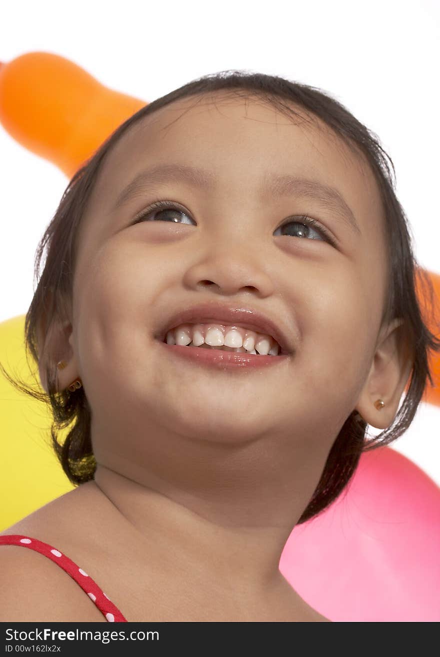 Girl looking up smiling over the balloons