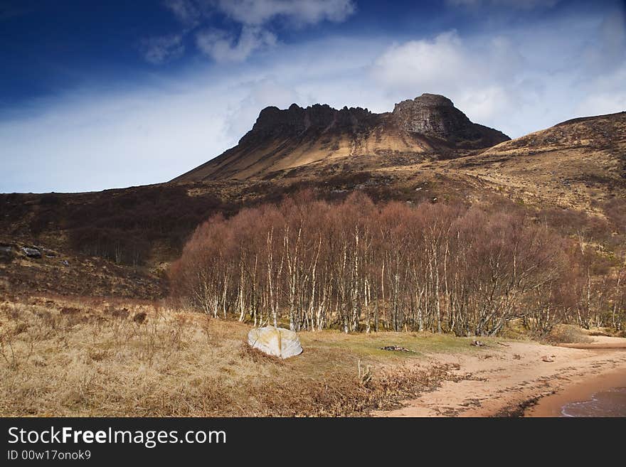 Stac Pollaidh above a small loch beach with boat