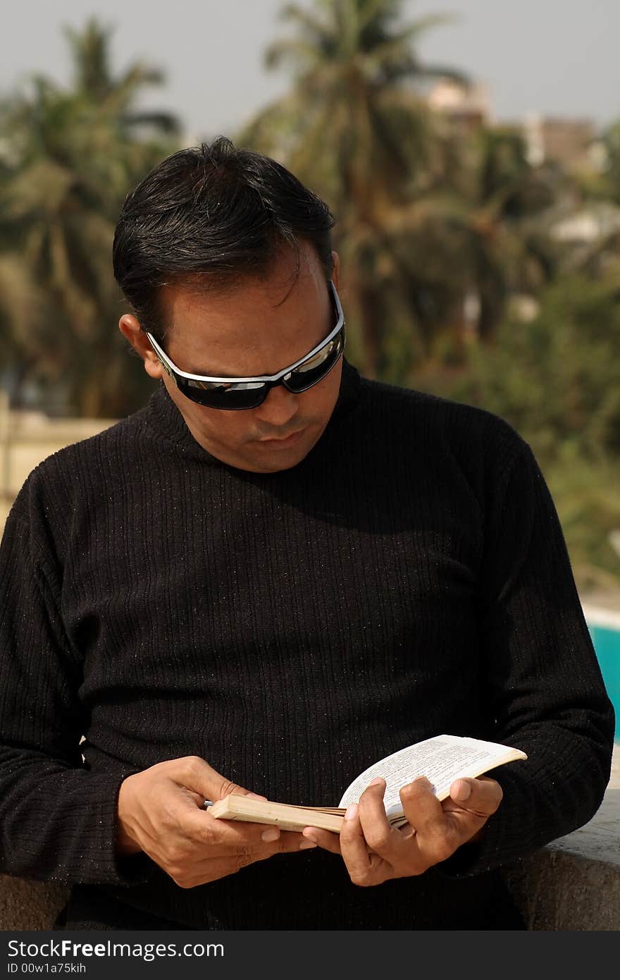 A stylish young man reading the book.