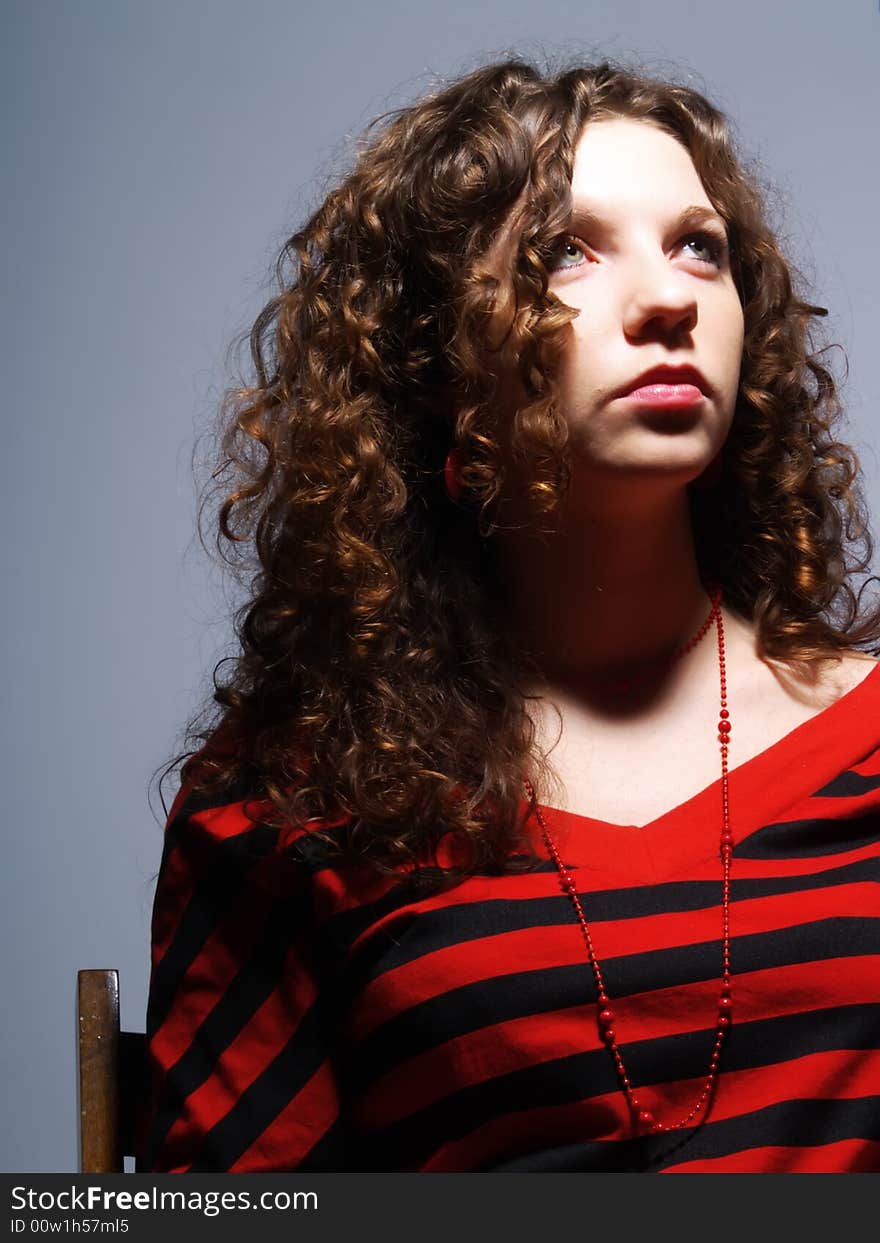 A portrait about a cute lady with white skin and long brown wavy hair who is looking up but she is unhappy. A portrait about a cute lady with white skin and long brown wavy hair who is looking up but she is unhappy