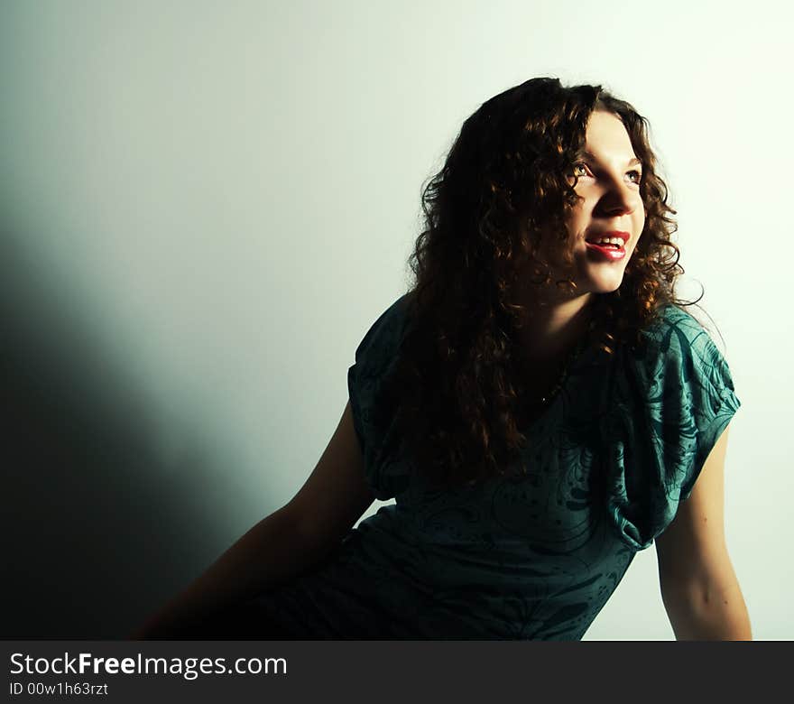 A portrait about a pretty lady with white skin and long brown wavy hair who wears a nice green dress and she is laughing. A portrait about a pretty lady with white skin and long brown wavy hair who wears a nice green dress and she is laughing