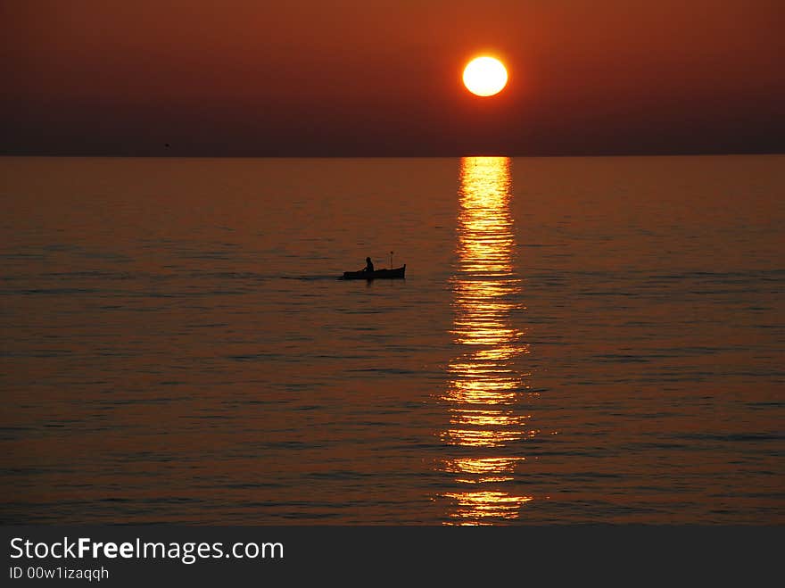 Man on a rowing boat. Sunset. Liguria Region, Italy