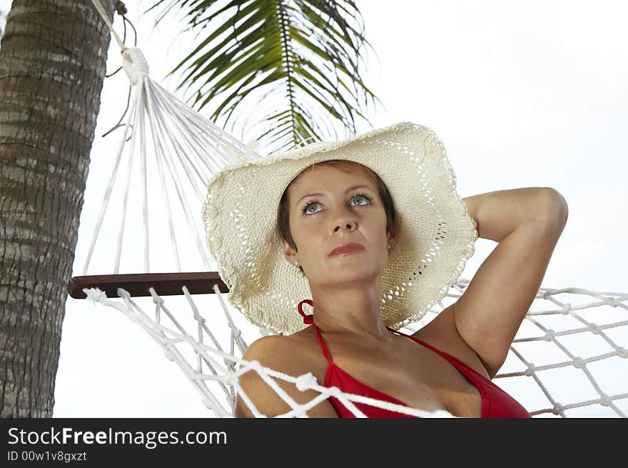 View of nice woman lounging in hammock in tropical environment