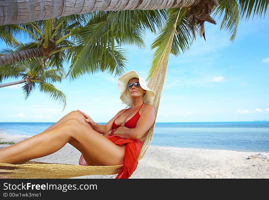 View of nice woman lounging in hammock in tropical environment. View of nice woman lounging in hammock in tropical environment