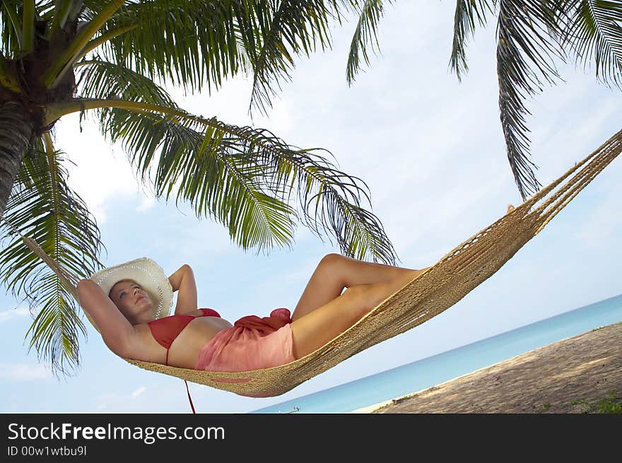 View of nice woman lounging in hammock in tropical environment. View of nice woman lounging in hammock in tropical environment