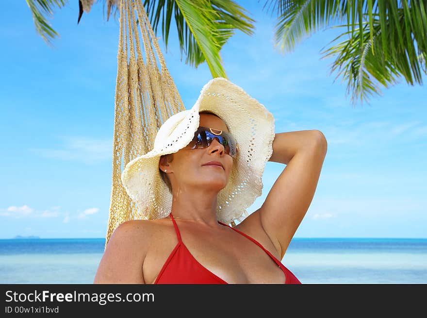 View of nice woman lounging in hammock in tropical environment. View of nice woman lounging in hammock in tropical environment