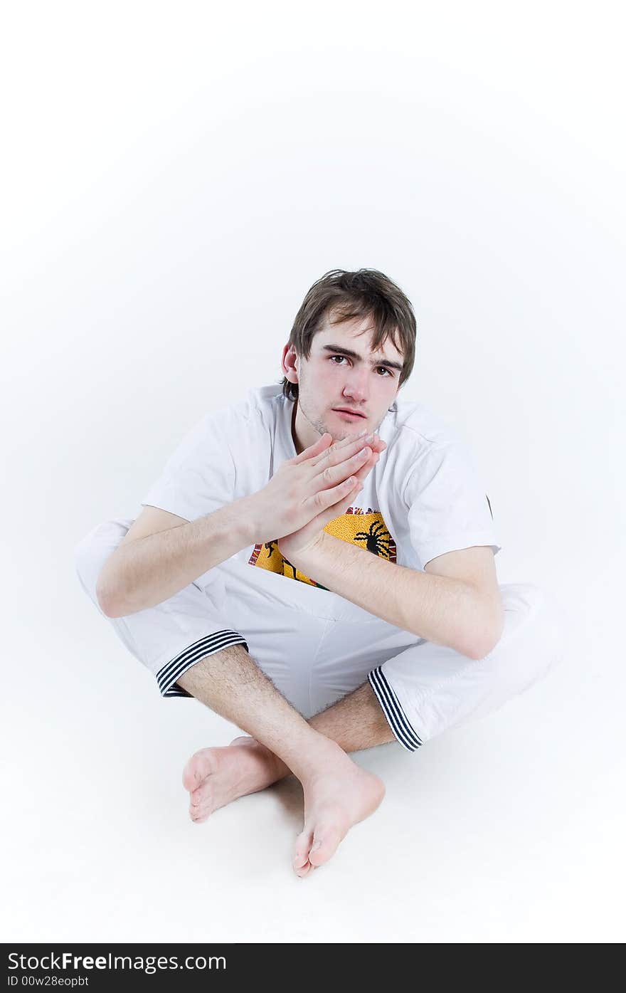 Serious teenager sitting in lotus poses, isolated on white background