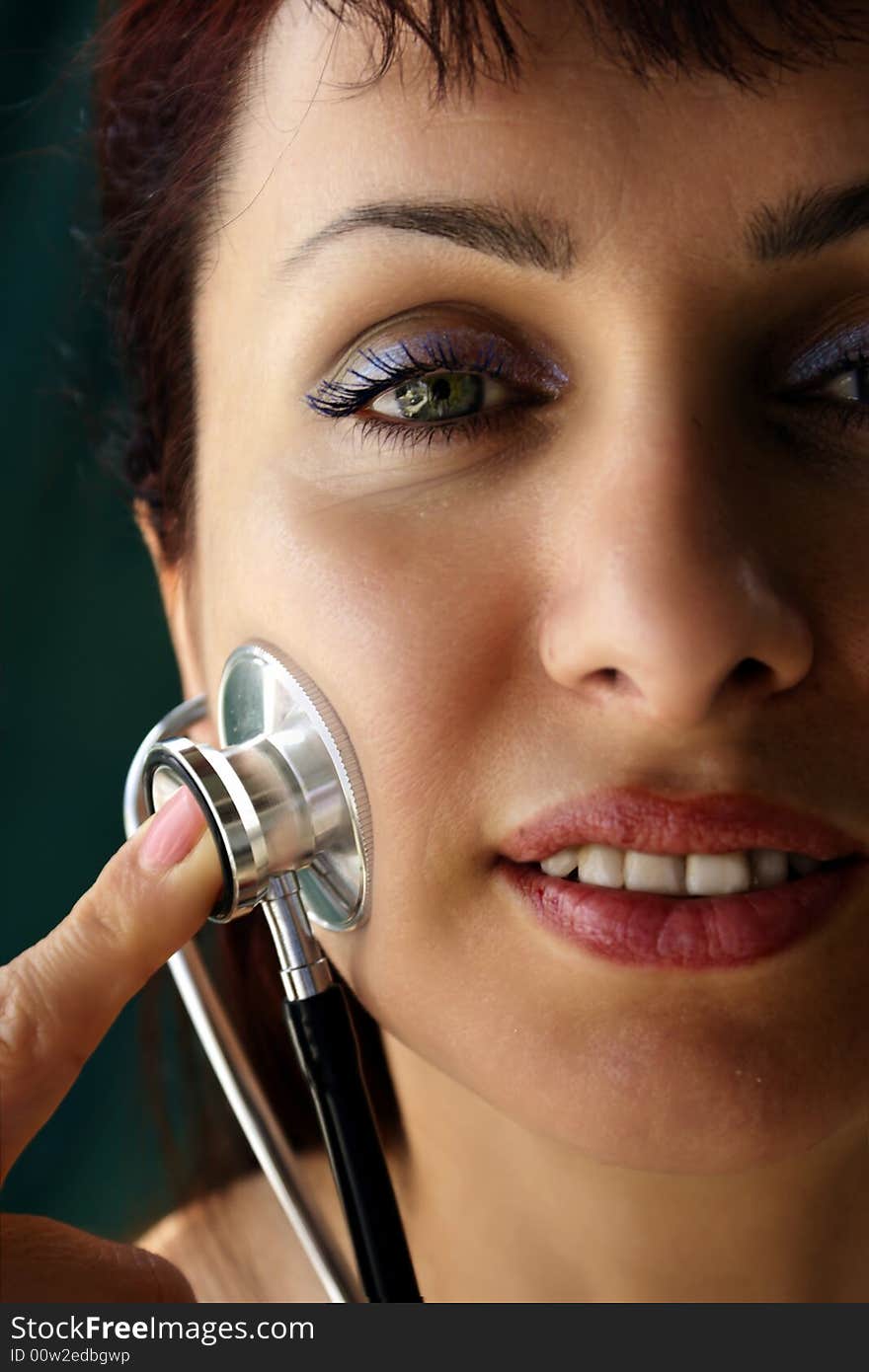 Young woman examining herself by using a stethoscope. Young woman examining herself by using a stethoscope