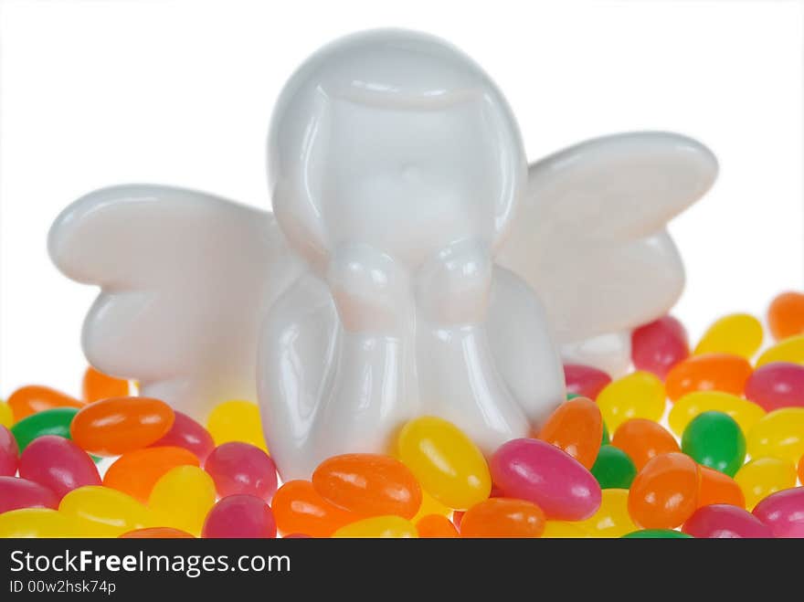 Close up to ceramic white angel placed over colorful Easter Candy. Close up to ceramic white angel placed over colorful Easter Candy