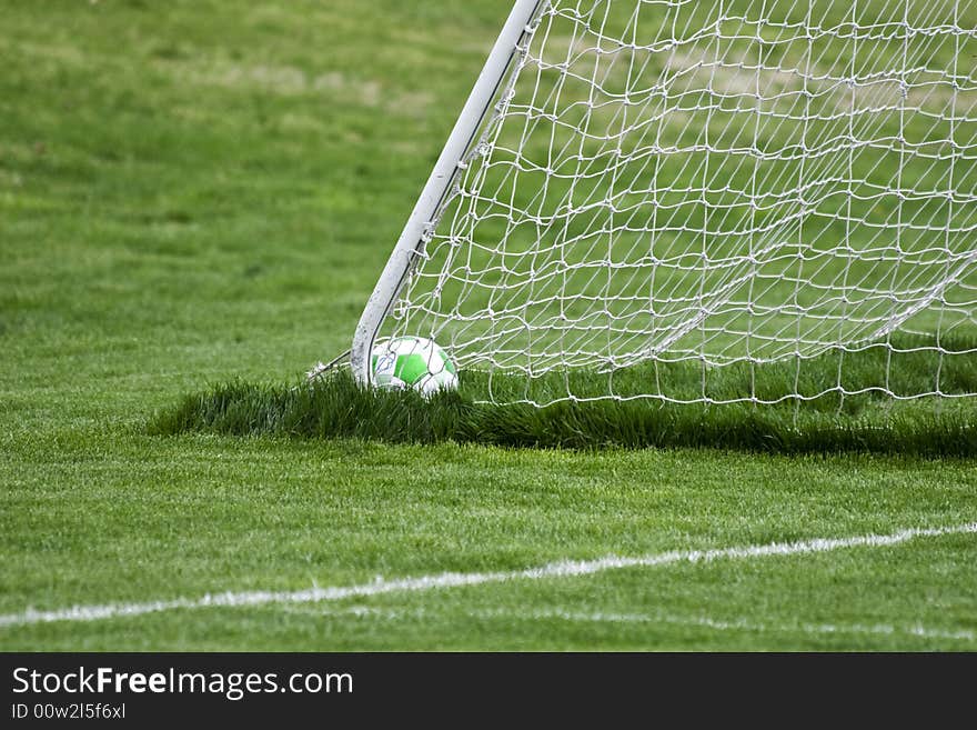 Soccer ball sitting in the back corner of the goal. Soccer ball sitting in the back corner of the goal.