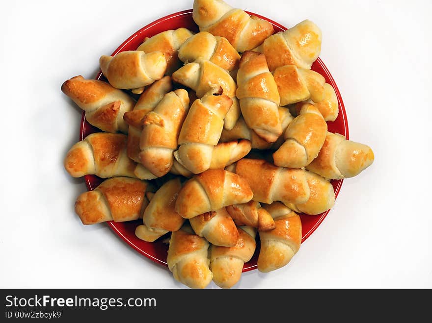 Appetizing rolled hand-made pastry on red plate isolated over white. Appetizing rolled hand-made pastry on red plate isolated over white