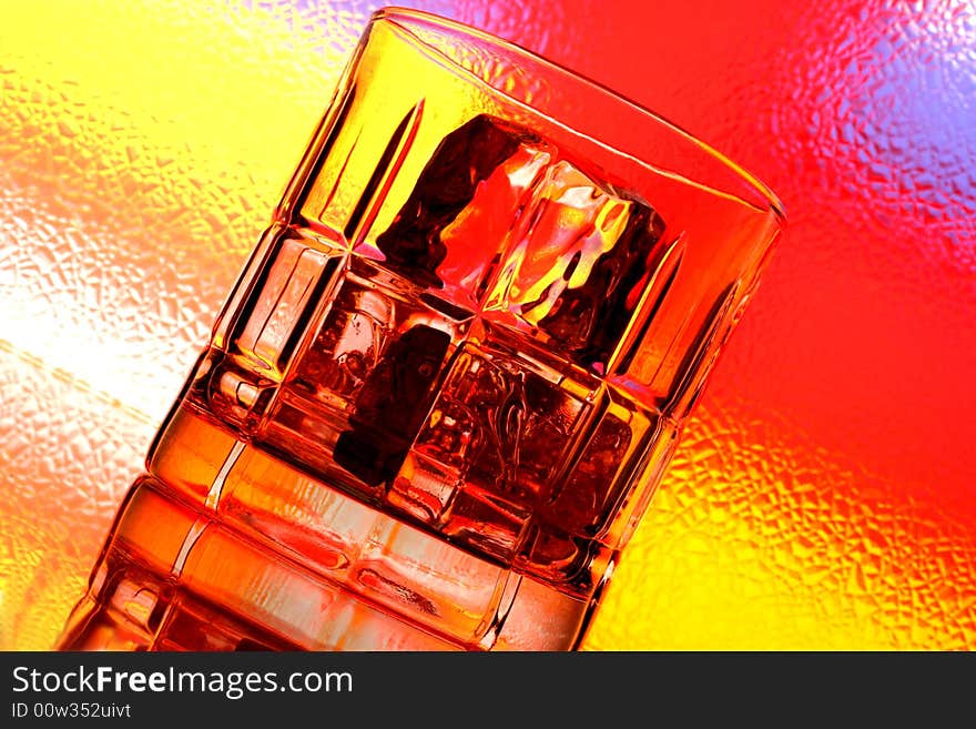 Glass of whiskey against multi colored abstract background. Glass of whiskey against multi colored abstract background.