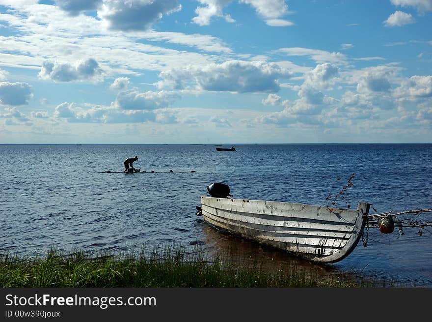 Lake View With Old Fishing Boat And Washing Woman