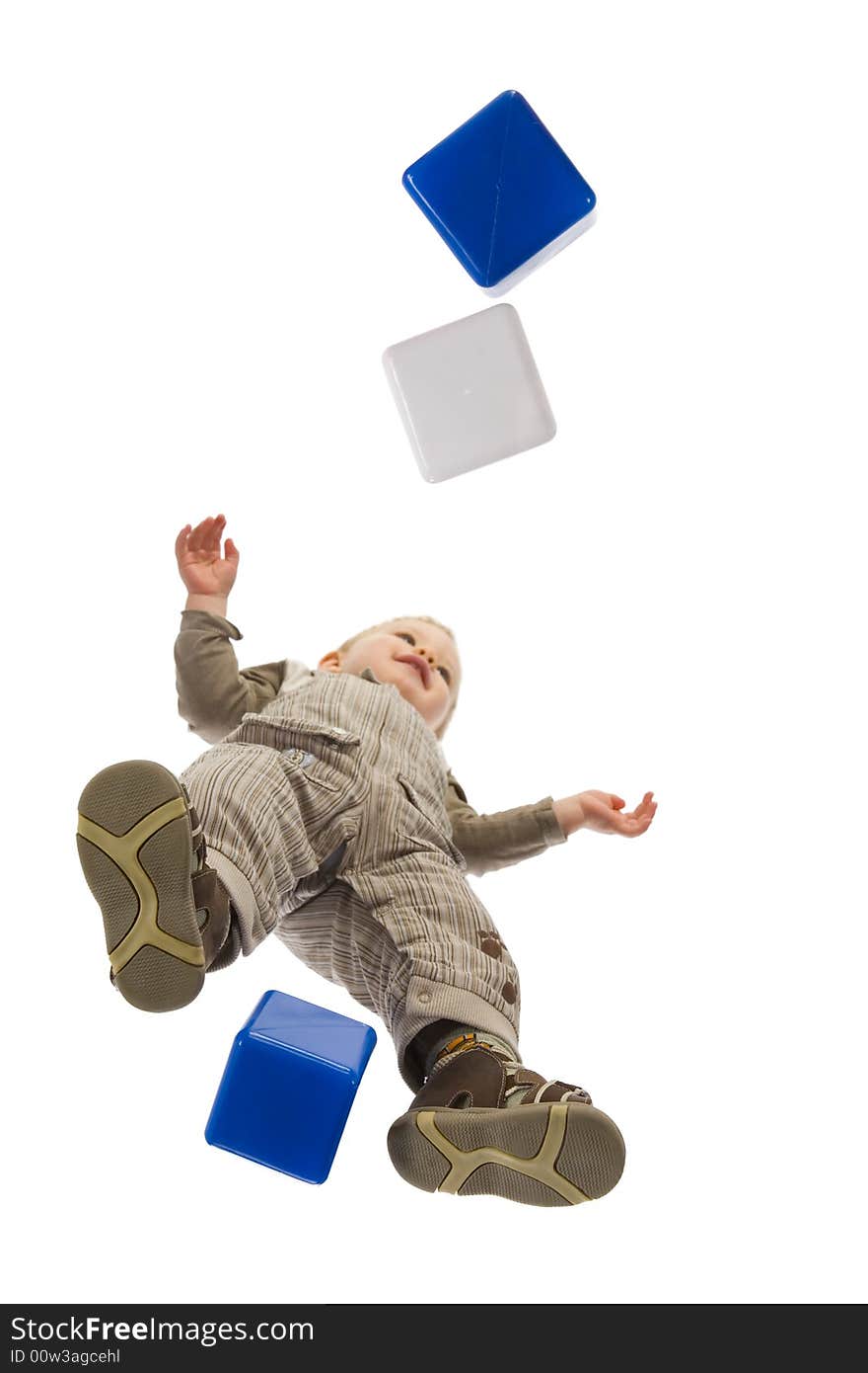 A little boy standing over blocks. Isolated on white background. Unusual angle view - directly below. A little boy standing over blocks. Isolated on white background. Unusual angle view - directly below.