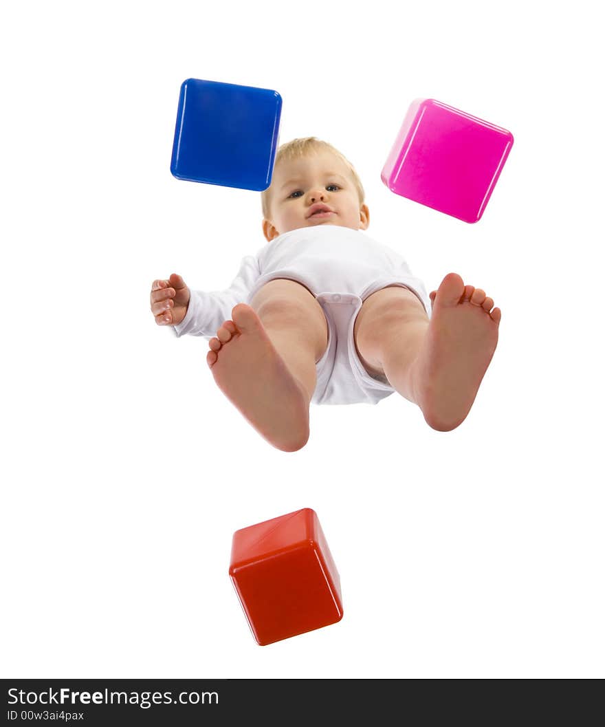 A little boy standing over blocks and looking at camera. Isolated on white background. Unusual angle view - directly below. A little boy standing over blocks and looking at camera. Isolated on white background. Unusual angle view - directly below.