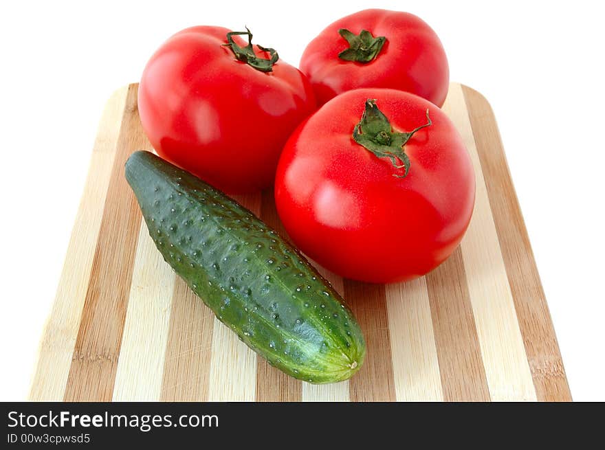 Vegetables (tomatoes and cucumber) on bamboo cutting board. Vegetables (tomatoes and cucumber) on bamboo cutting board.