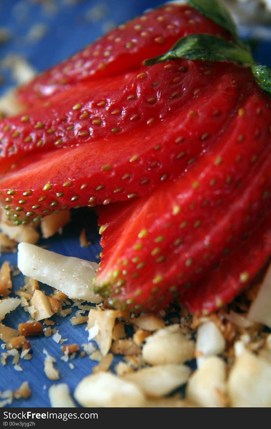 Close-up/macro of strawberry and nuts on a blue plate