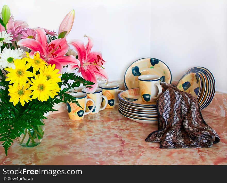 Clean dishes on the kitchen table with fresh flowers. Clean dishes on the kitchen table with fresh flowers