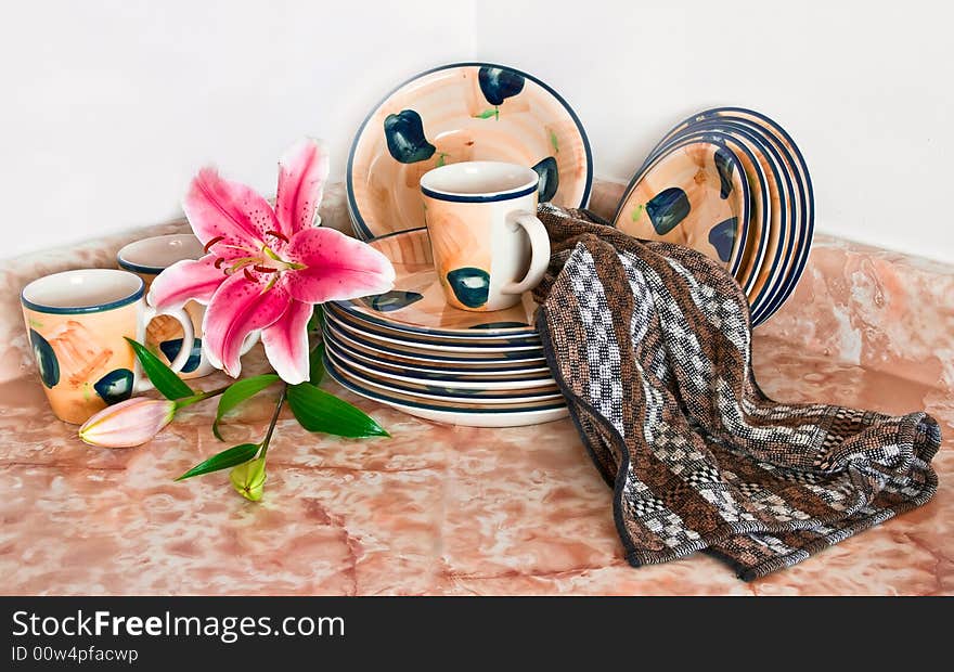 Clean dishes on the kitchen table with fresh flowers. Clean dishes on the kitchen table with fresh flowers