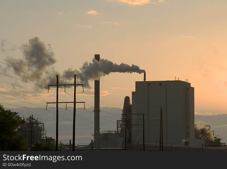 View of paper mill at sunset discharging into the air. View of paper mill at sunset discharging into the air