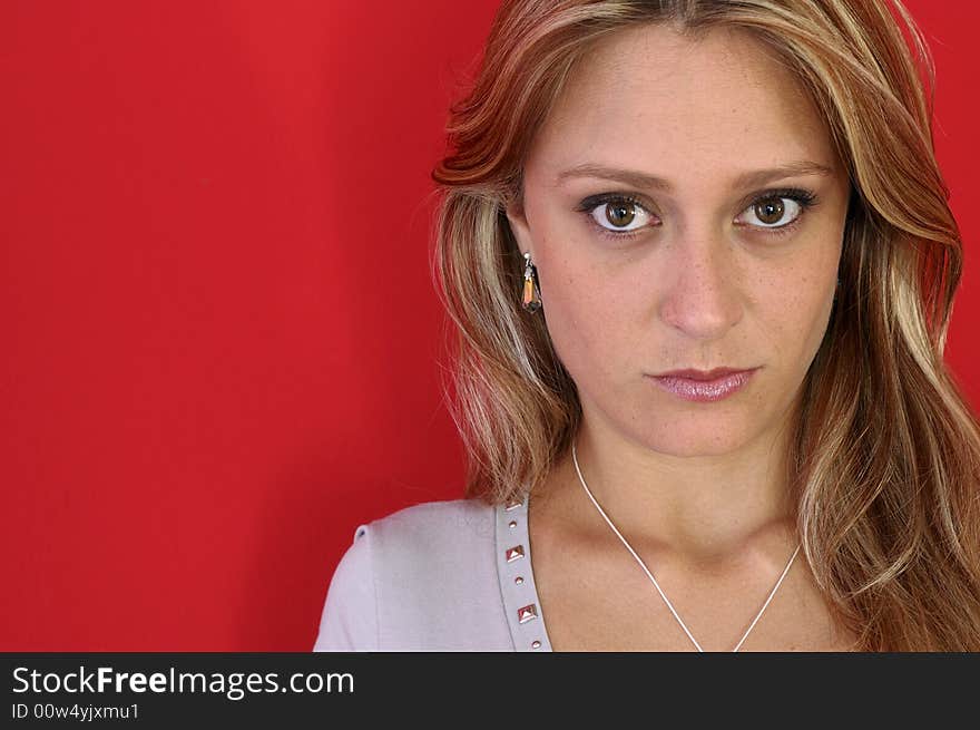 Attractive woman look to the camera on the red background. Attractive woman look to the camera on the red background