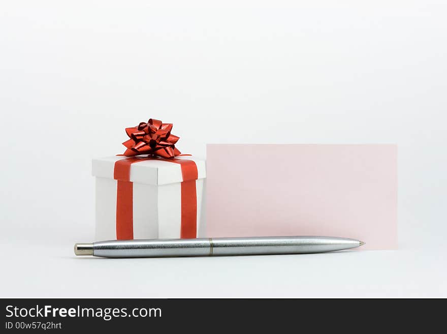 White fancy box, blank pink note and a silver pen. White fancy box, blank pink note and a silver pen