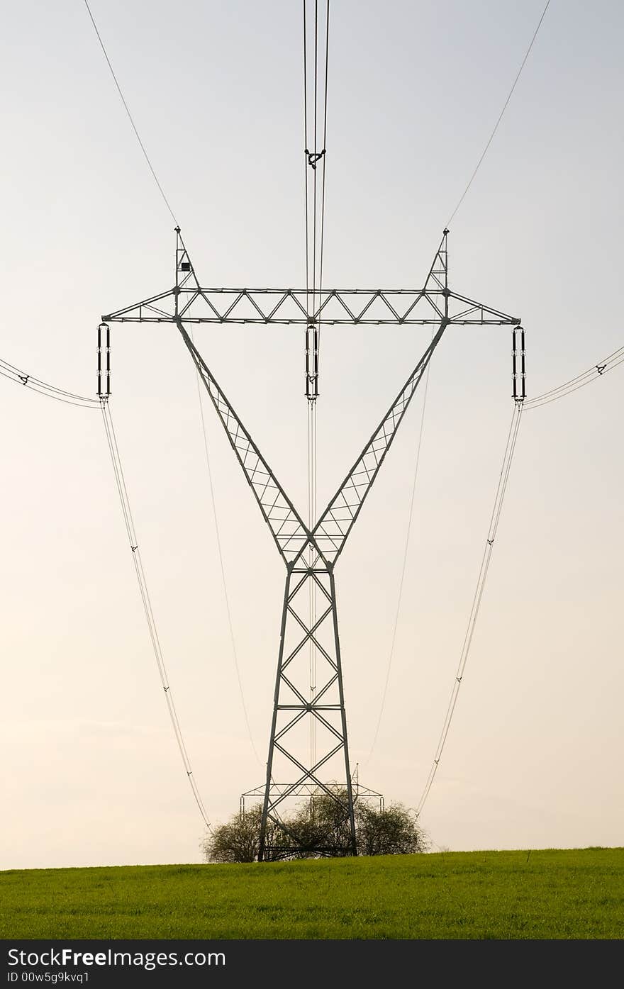 Silhouette of the electricity pylon with cables and the blue sky