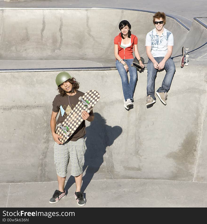 Teen skateboarders hang out at a skate park. Teen skateboarders hang out at a skate park