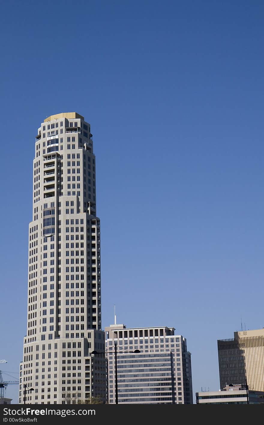 A single tall grey tower rising from the city skyline. A single tall grey tower rising from the city skyline