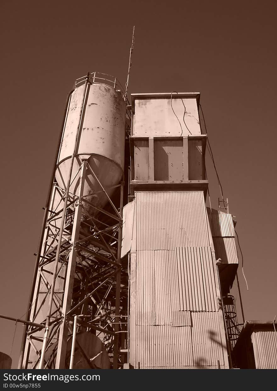 Cement factory in Berkeley California.  Sepia color.  Corrigated surface, run down, used.