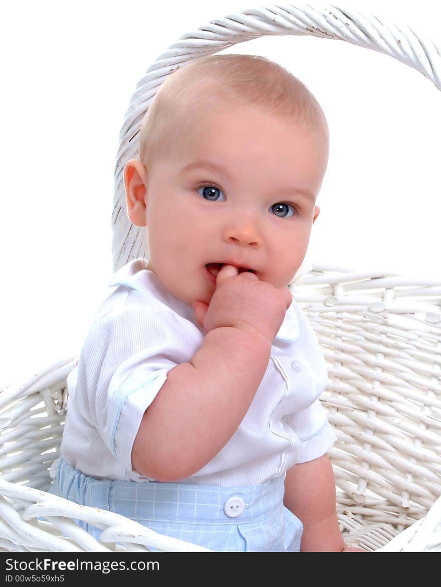 Closeup of baby boy in front of white background with hand in mouth