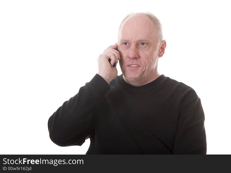 An older guy in a black shirt talking on a cell phone and smiling. An older guy in a black shirt talking on a cell phone and smiling