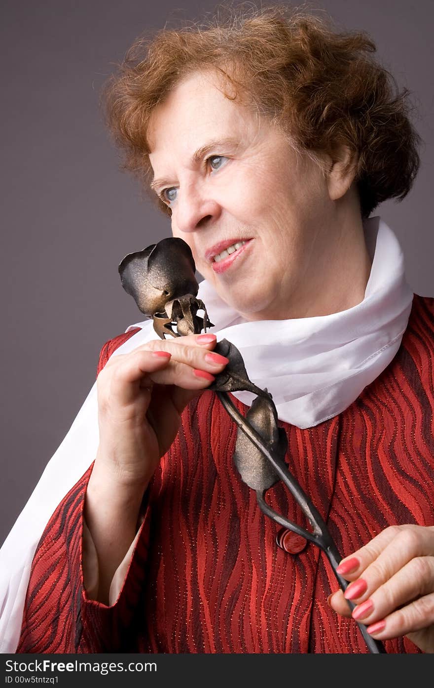 The pleasant elderly woman on gray background. The pleasant elderly woman on gray background.