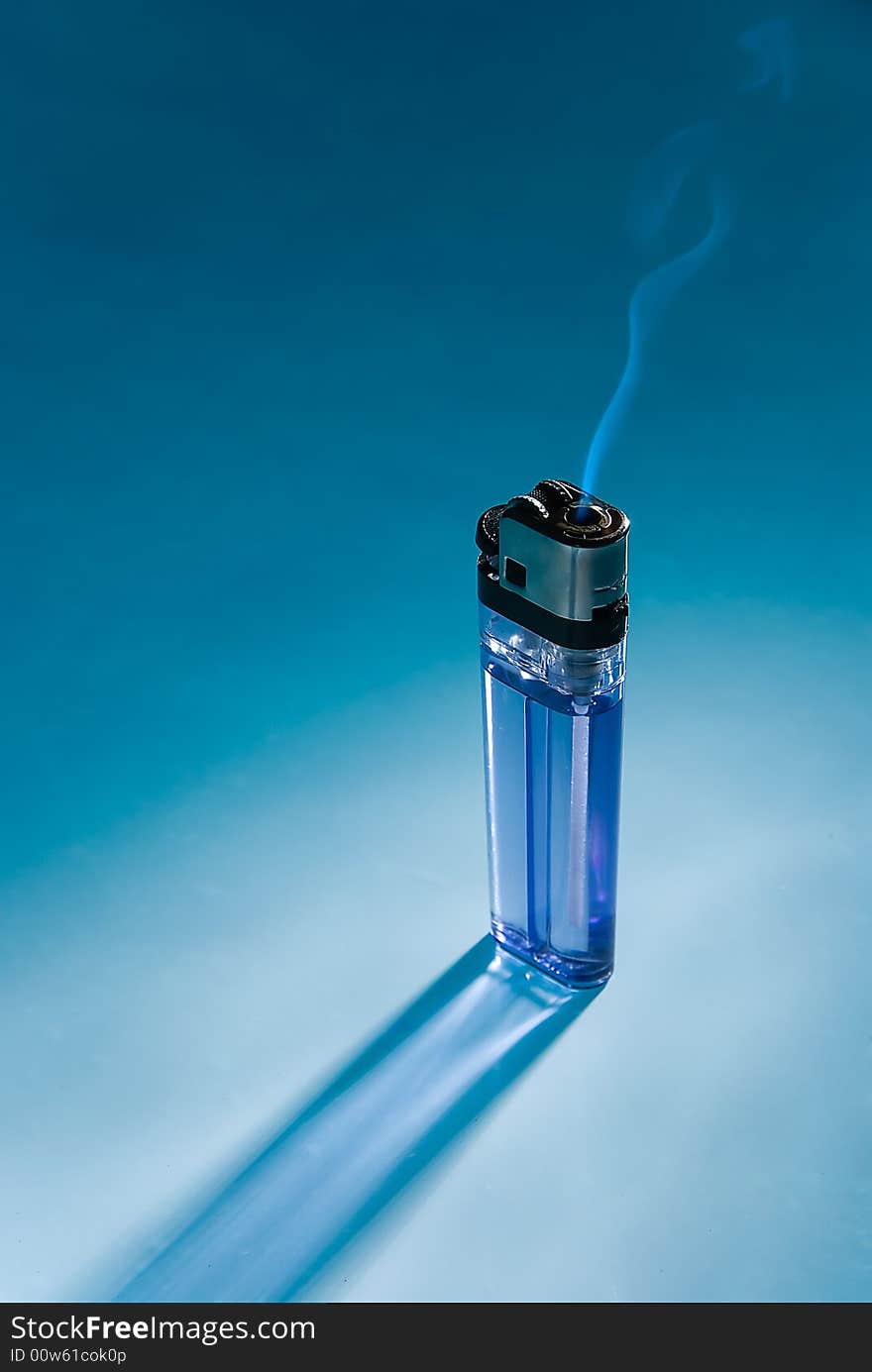 The fuming cigarette lighter on blue