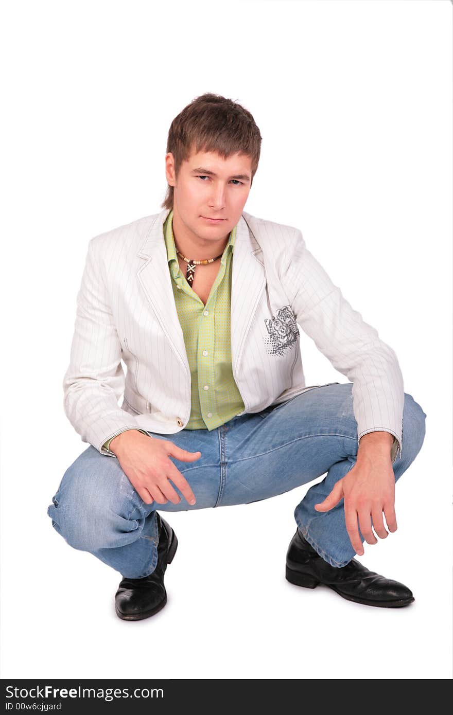 Serious young man sits on white