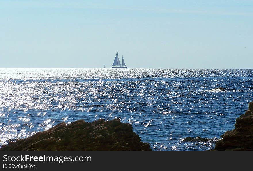 Sailboat at sunset in the Straits of Bonifacio, the wind-swept waterway that separates the coast of France from Italy.