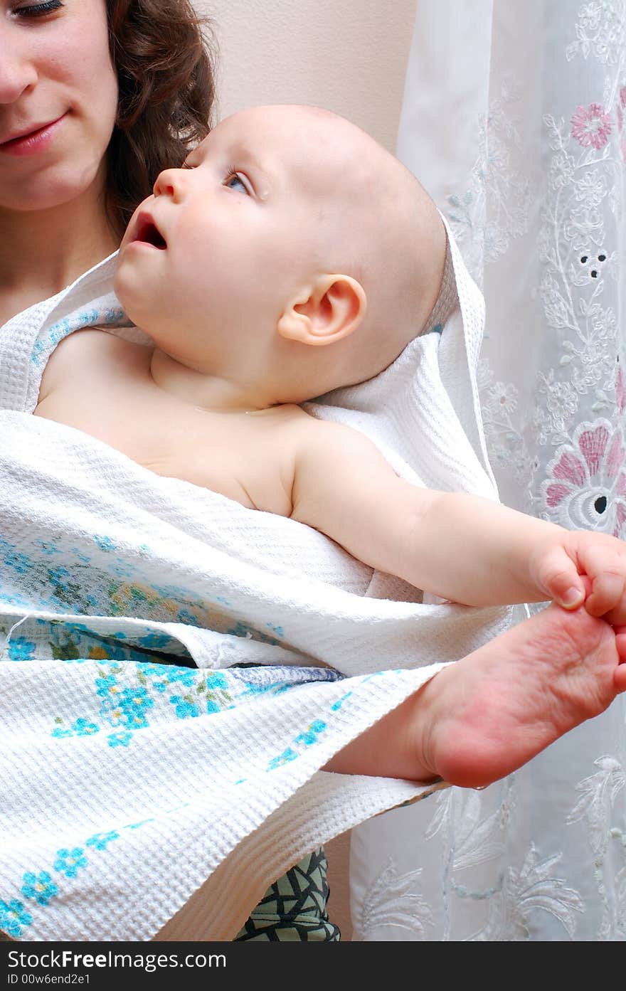 Little baby seize leg into his hand. On hands his happy mother