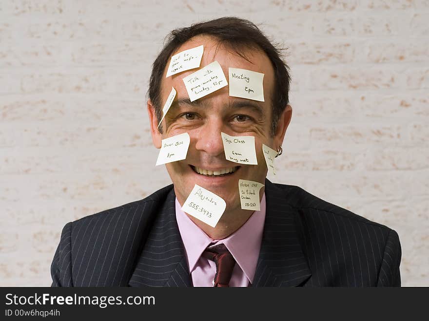 A shot of a business man's head covered in yellow stickynotes. A shot of a business man's head covered in yellow stickynotes.