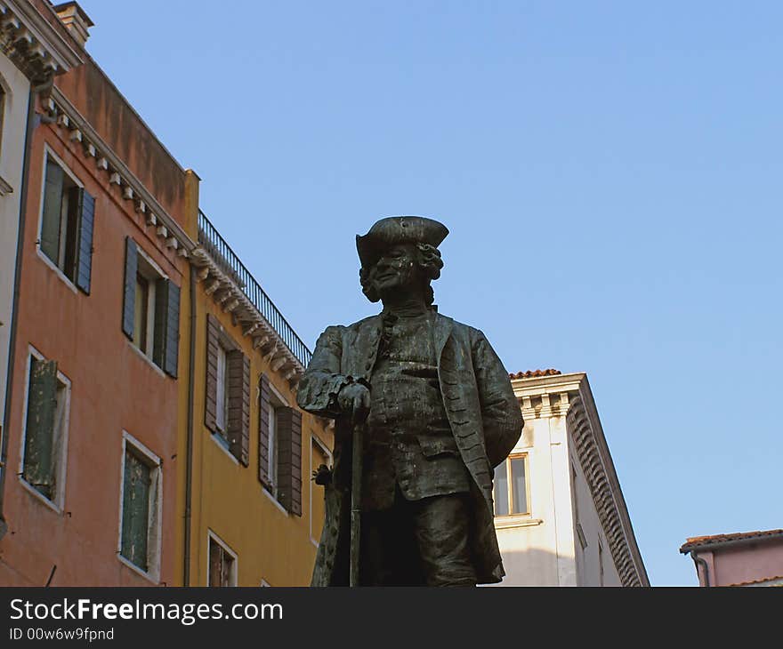 Venice (Italy) postcard: statue of a noble man against clear blue sky and colorful palace facades, with space for text (copyspace)