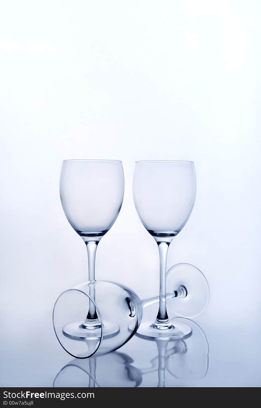 Three empty wine glasses on blue background